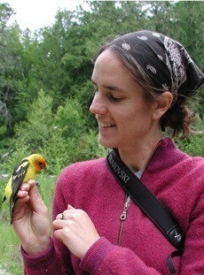 Kristen Ruegg holding a yellow bird in nature