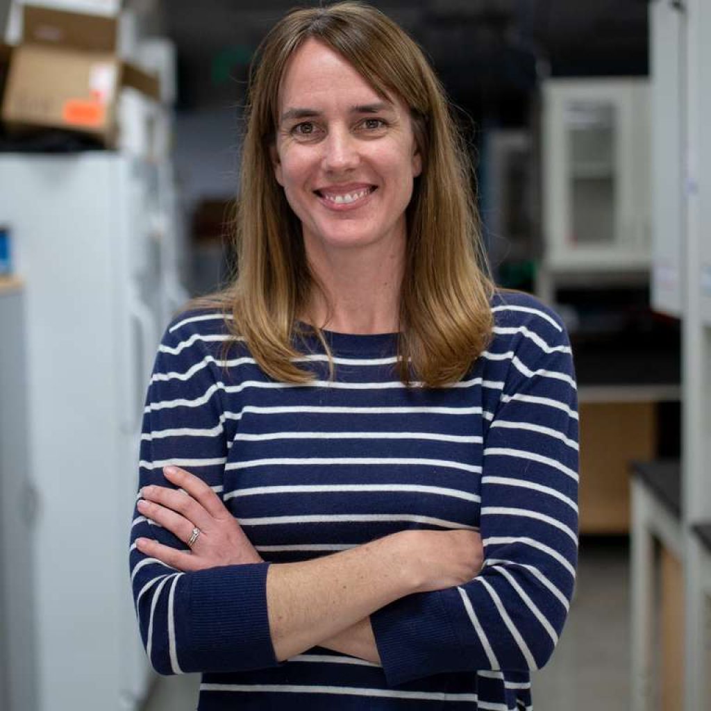 Portrait of Kristen Ruegg in a lab smiling at the camera