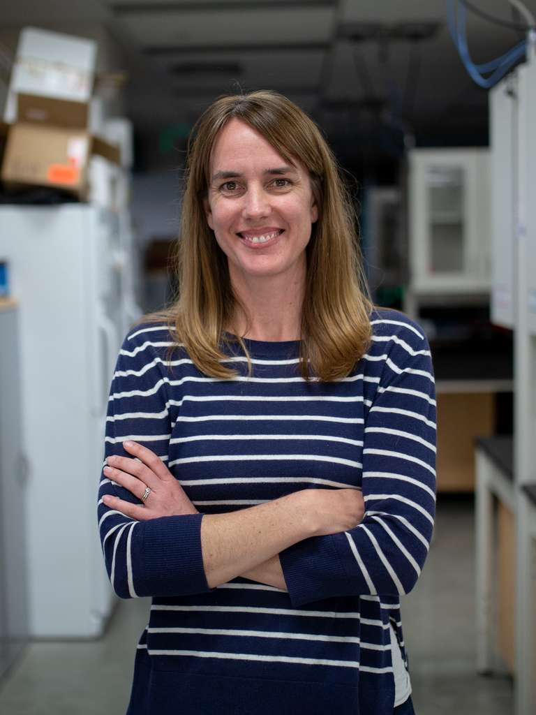 Portrait of Kristen Ruegg in a lab smiling at the camera