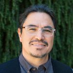 Dr. José R. Dinneny headshot with green nature background