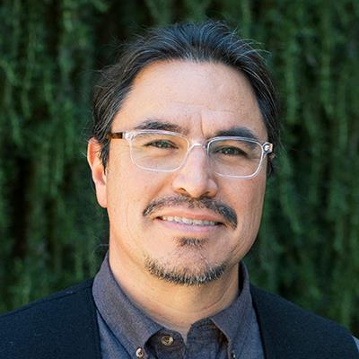 Dr. José R. Dinneny headshot with green nature background