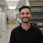 Amir Alayoubi smiling at the camera while standing the CSU Biology lab.